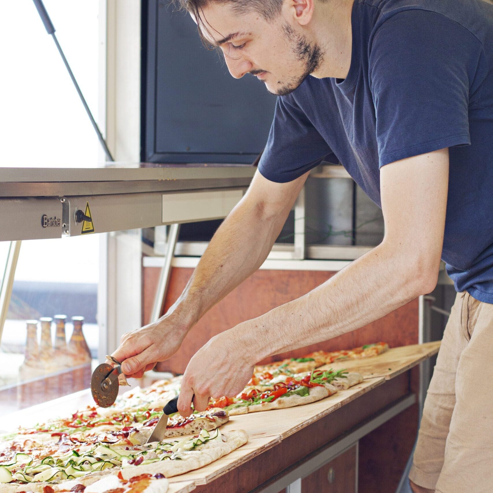 Pizza schneiden im Foodtruck